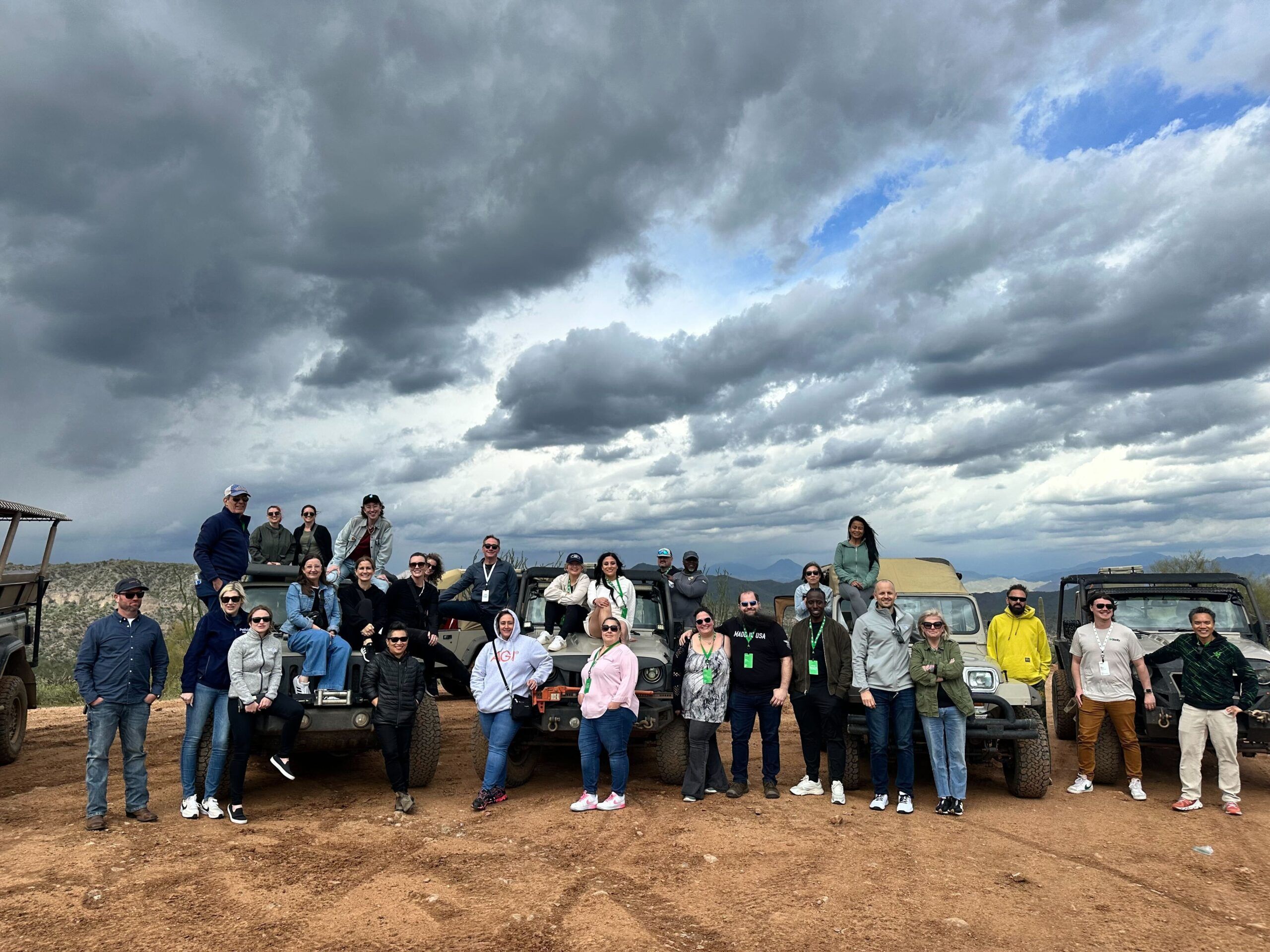 A group of people standing together under an open, cloudy sky
