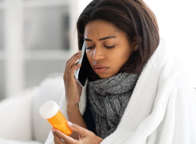 woman on phone looking at medication