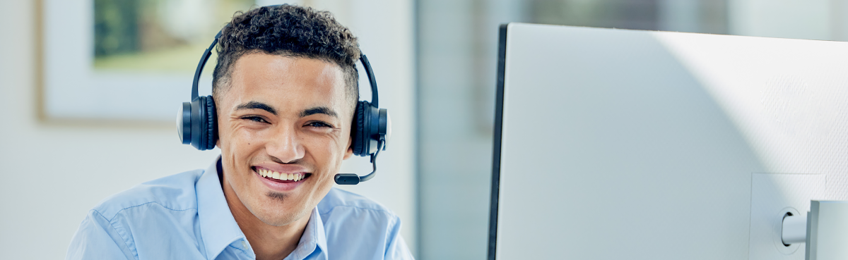 Man wearing headset in front of desktop computer