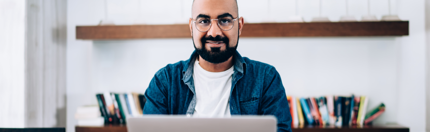 Man smiling working on a laptop