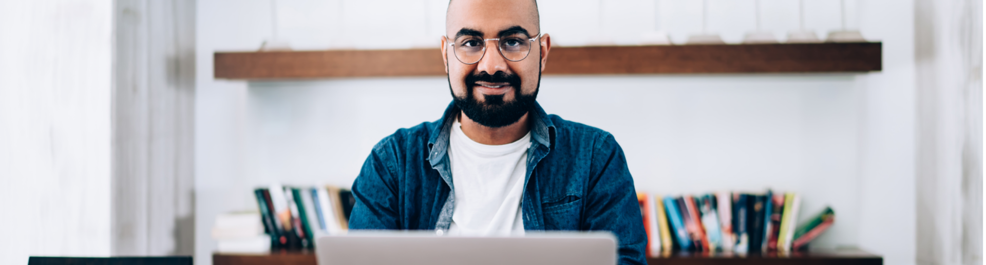 Man smiling working on a laptop