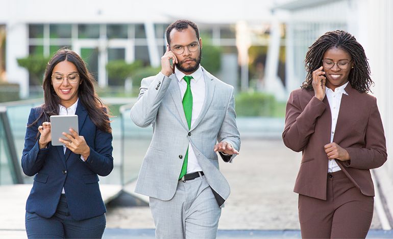 From left to right, a happy woman with a tablet, a frowning man on a cell phone, and a smiling woman on a cellphone