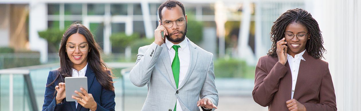 From left to right, a happy woman with a tablet, a frowning man on a cell phone, and a smiling woman on a cellphone