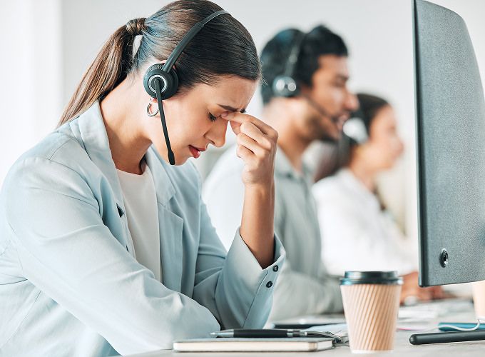Frustrated customer support agent pinching the bridge of her nose