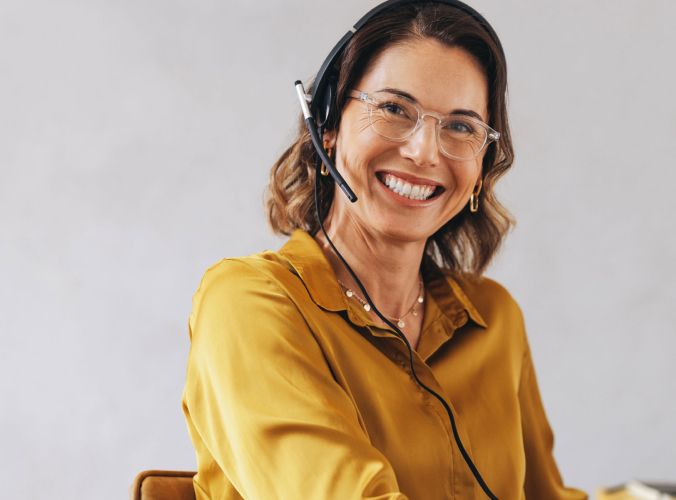 Customer service agent wearing a headset and smiling at camera