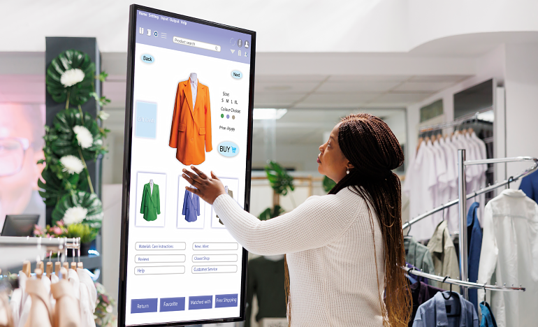 Woman using in-store tablet to shop for clothes