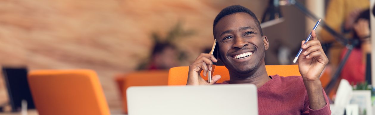 Man smiling while having a conversation on his mobile phone