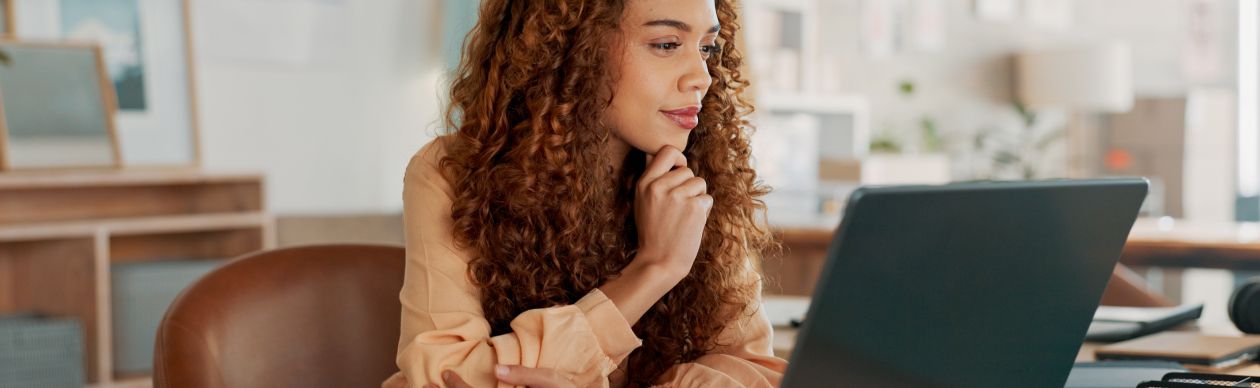 A CX expert on her computer researching on whether she should renew with her current CX platform or start anew