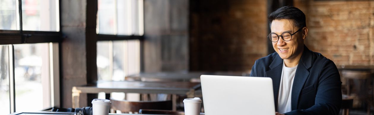 Bespectacled man working on a laptop