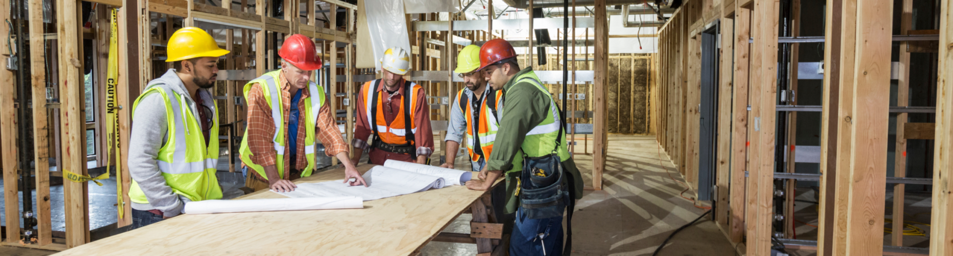 Construction workers talking around blueprints