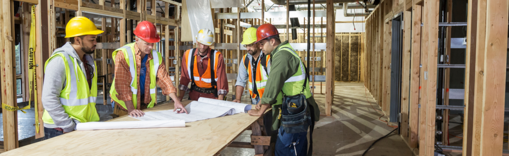 Construction workers talking around blueprints