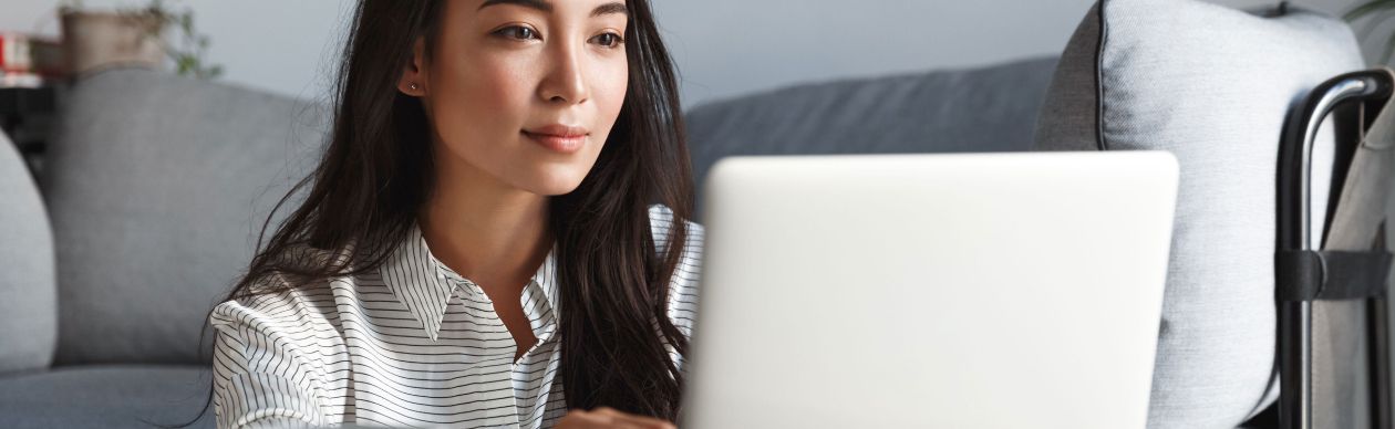 Woman sitting in a living room and looking at her laptop