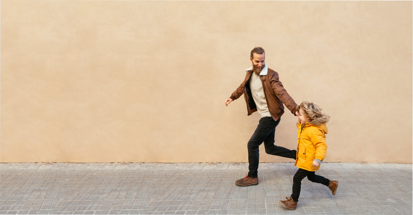 Father running hand in hand with his toddler 