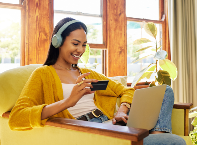 Woman in a yellow sweater using a laptop and credit card, smiling with headphones on. Text reads "7 ways AI-driven service boosts revenue and customer devotion" with Gladly logo.