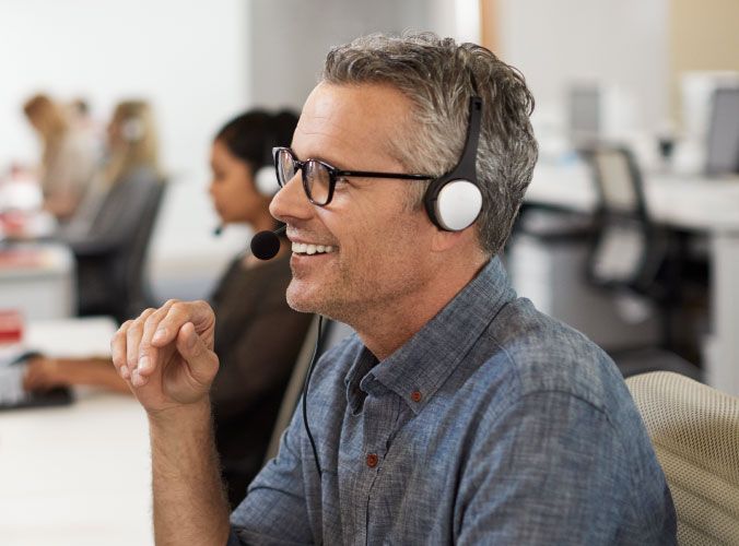 Smiling man with headset working customer service job