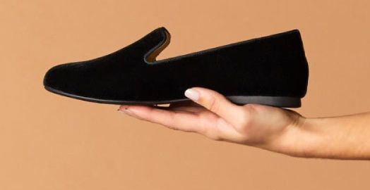 Hand holding Birdies brand shoe