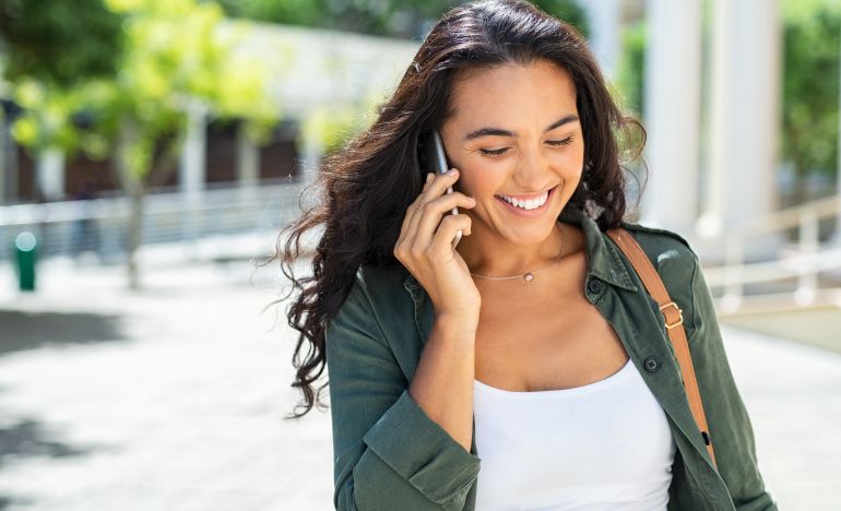 A smiling woman talking on the phone