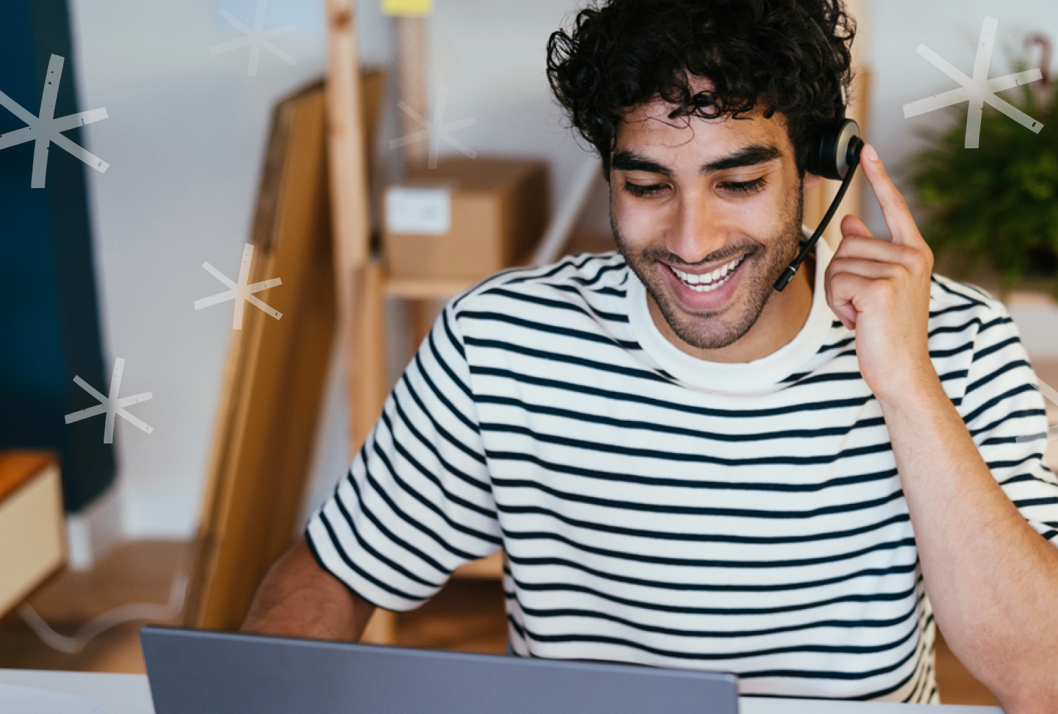 Man in a striped shirt wearing a phone headset and smiling
