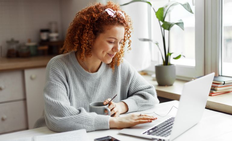 A CX expert on her computer who is happy she was able to reduce the cost of customer service