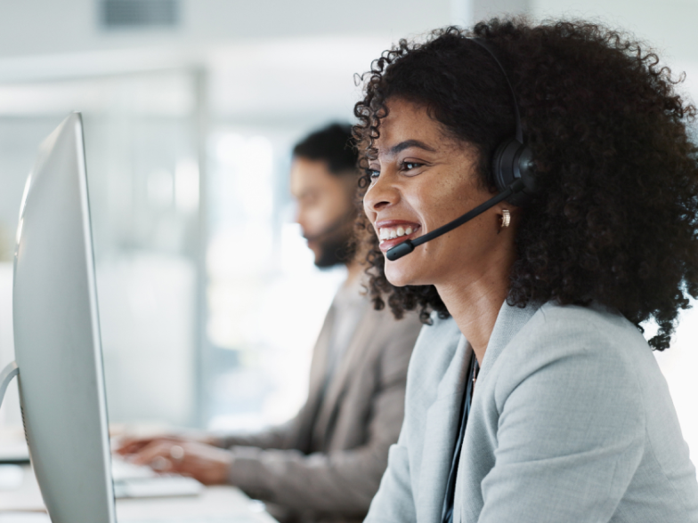 Customer support agent smiling at computer in office