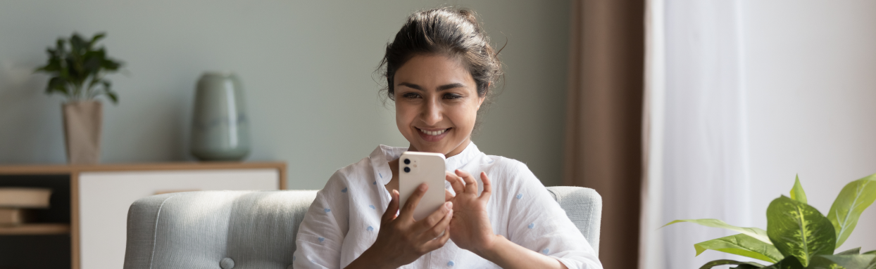 Smiling woman using her mobile phone