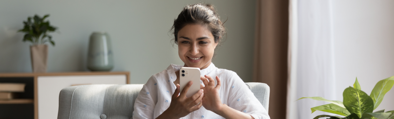 Smiling woman using her mobile phone