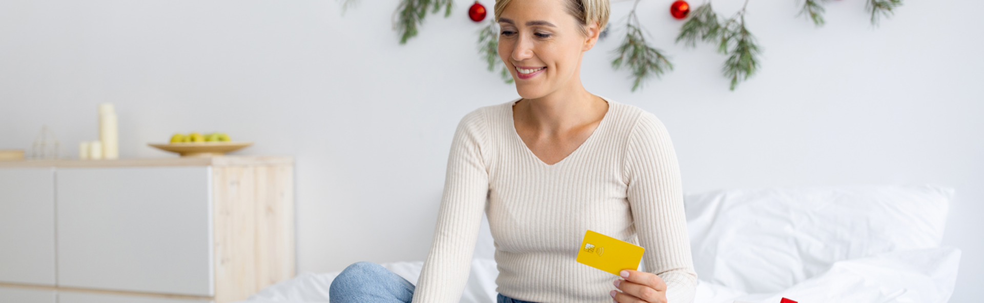 Woman smiling in a living room with Christmas decorations on the wall in the background