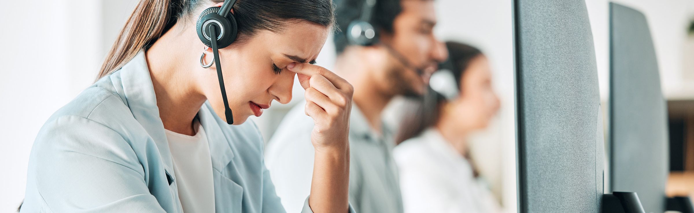 Frustrated customer support agent pinching the bridge of her nose