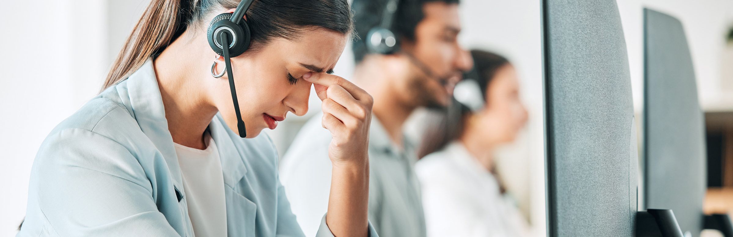 Frustrated customer support agent pinching the bridge of her nose
