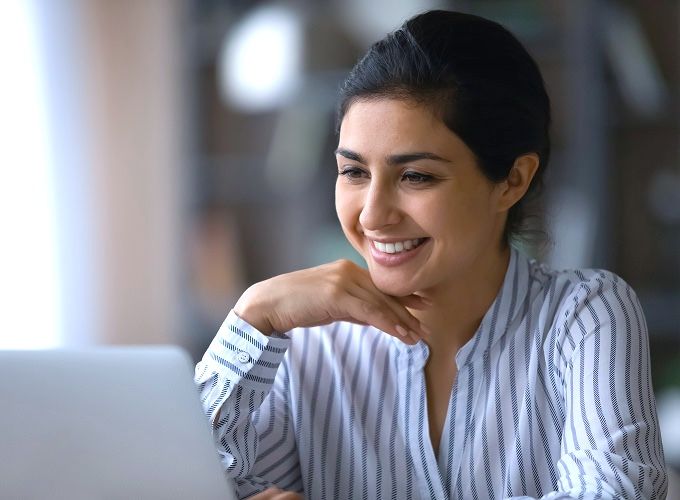 Woman smiling while looking at computer