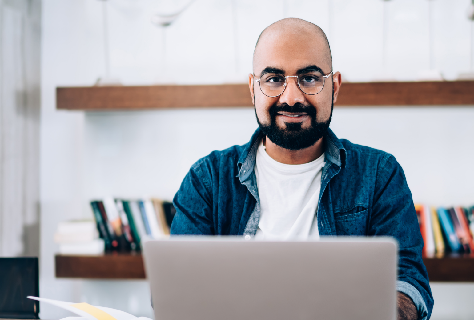 Man smiling working on a laptop