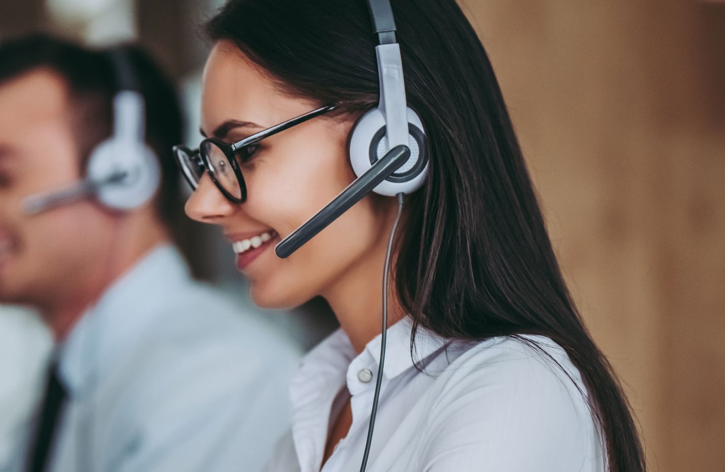 Woman customer service agent with headset working at her desk