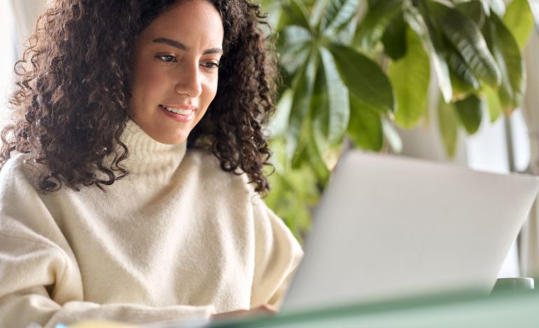 a woman researching gladly g2 customer service results on her laptop