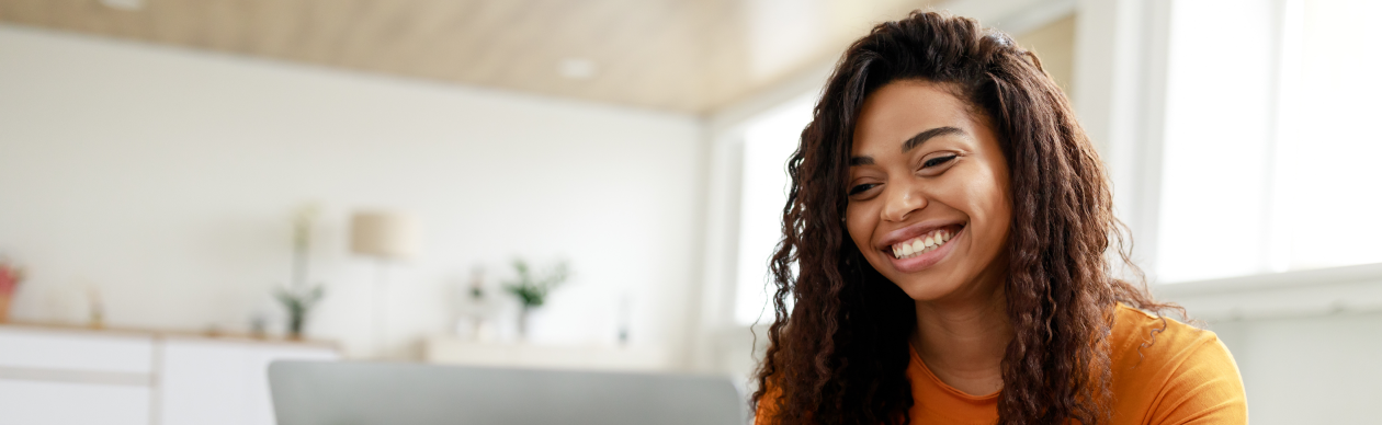 Woman taking notes while using her laptop