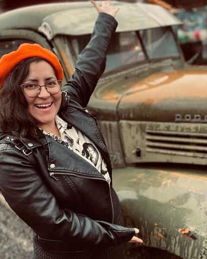 Mel Gutierrez gesturing to an old green Dodge truck