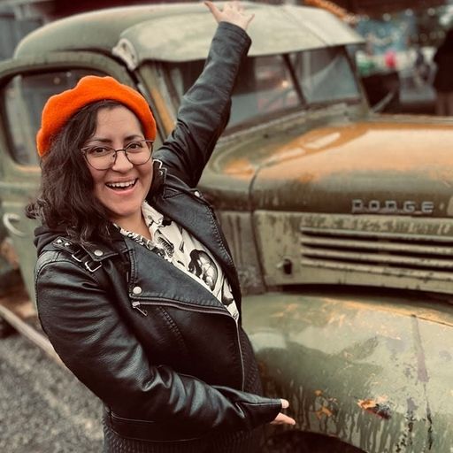 Mel Gutierrez gesturing to an old green Dodge truck