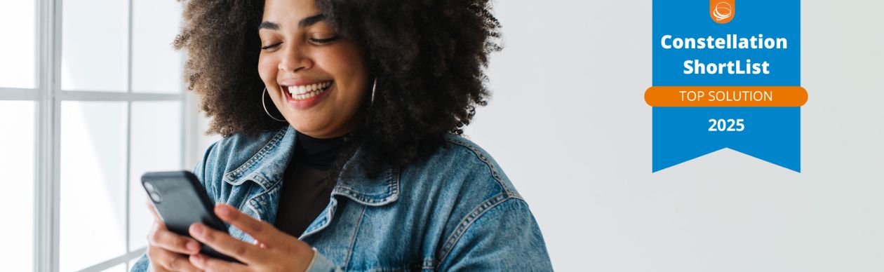 Smiling woman looking at a smartphone. On the right, a badge displaying "Constellation Shortlist Top Solution 2025."