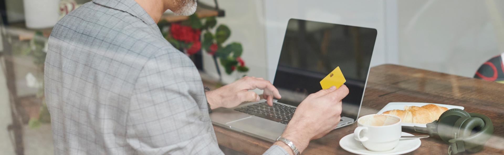 Someone preparing to buy something on their laptop, a credit card in their hand