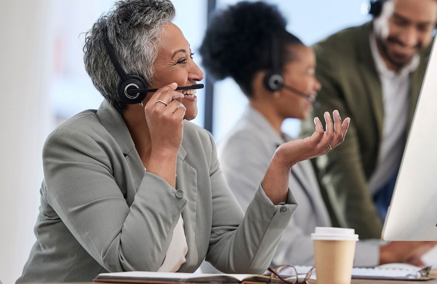 Smiling customer service agent talking on headset in office