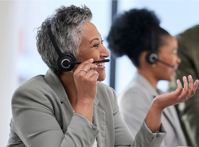 A woman on a headset talking and smiling