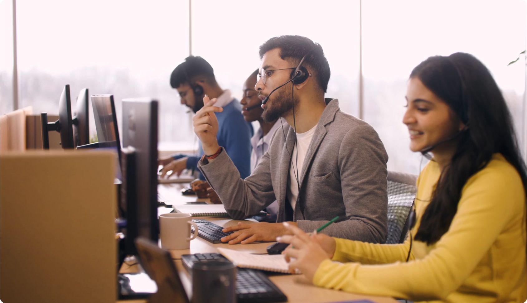 people sitting at computers and talking on headsets