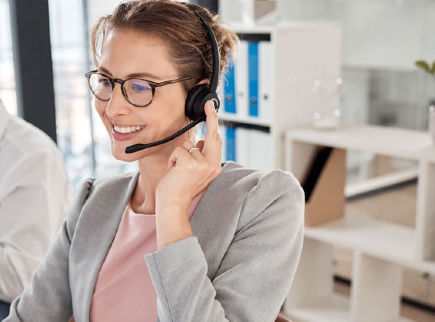 Woman support agent using headset to talk in office