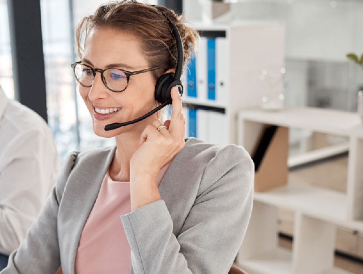 Woman support agent using headset to talk in office