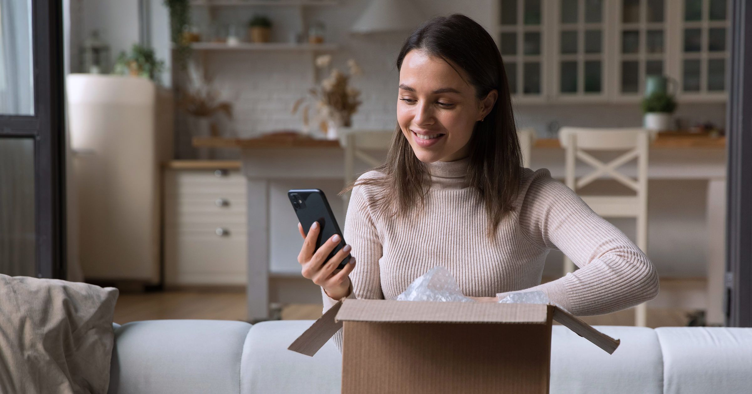 Woman on couch smiling at phone