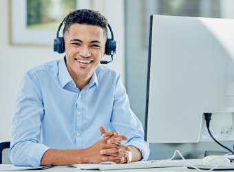 Man wearing headset in front of desktop computer