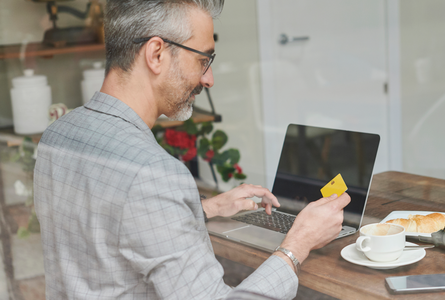 Someone preparing to buy something on their laptop, a credit card in their hand