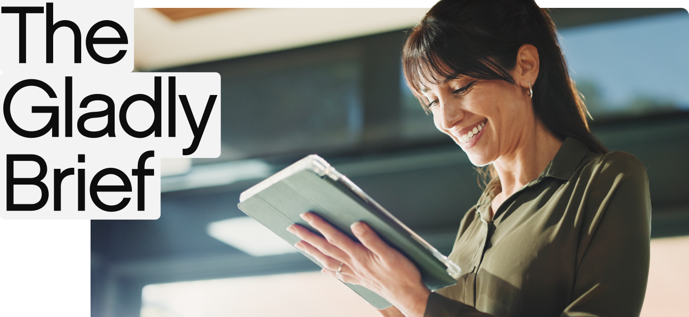 A woman in a green blouse smiles while holding a tablet. Bright indoor setting, with "The Gladly Brief" text overlay in bold black letters on the left.