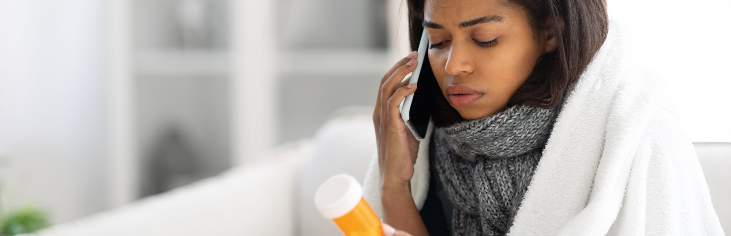 woman on phone looking at medication
