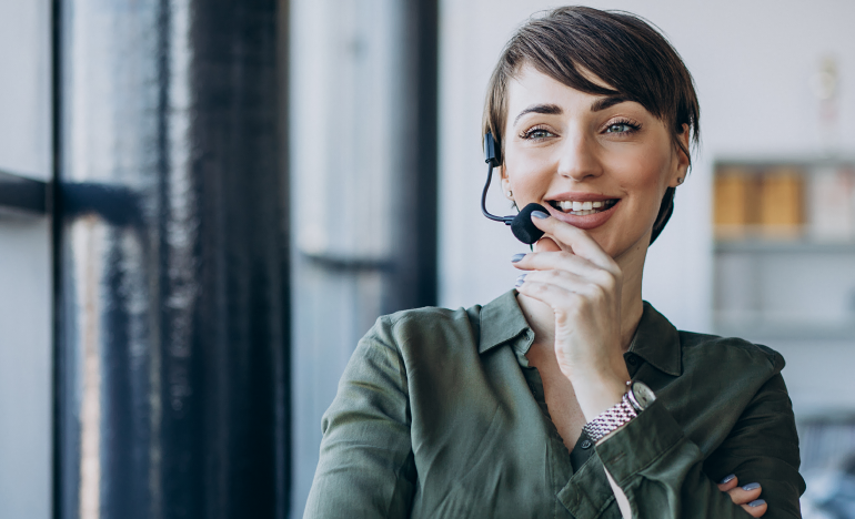 Woman with a phone headset smiling into the mic
