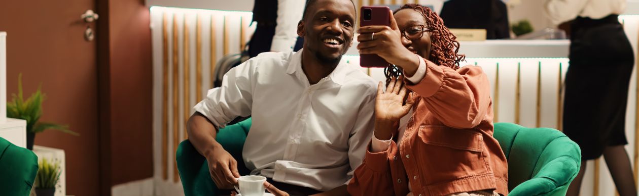 Two people smiling at a smartphone